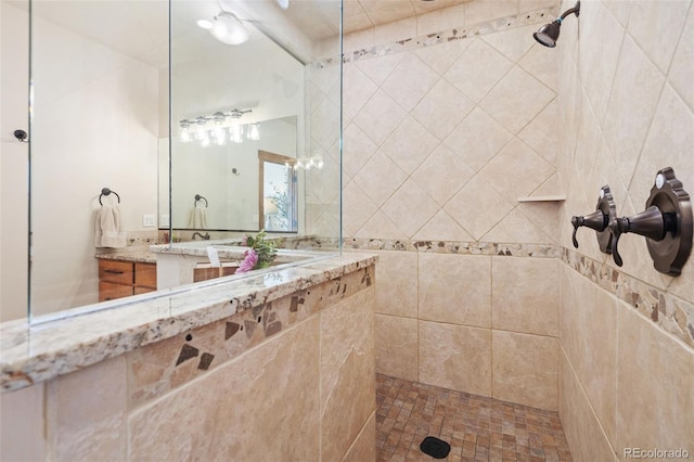 bathroom featuring tiled shower and vanity