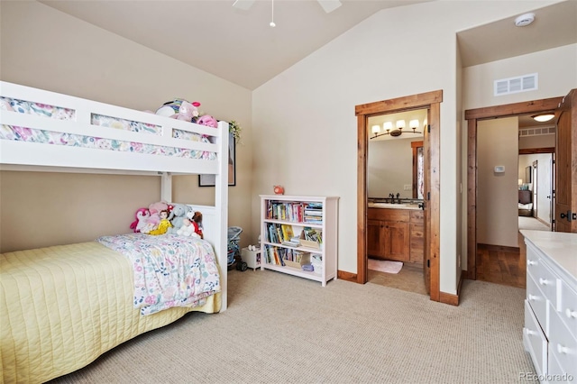 bedroom featuring lofted ceiling, connected bathroom, light colored carpet, and ceiling fan