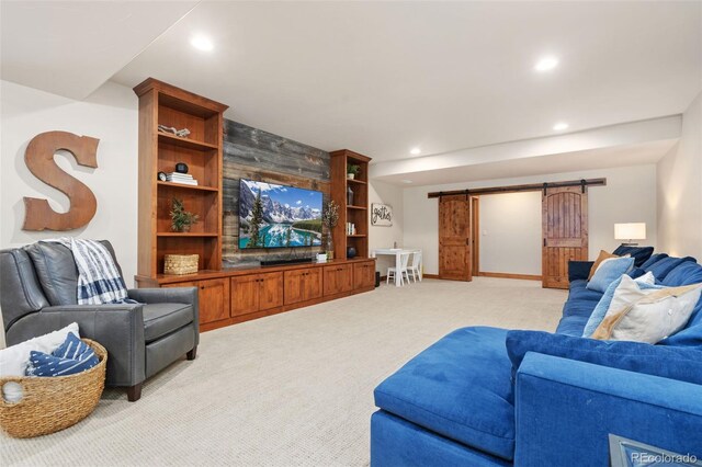 living room with built in shelves, light colored carpet, and a barn door