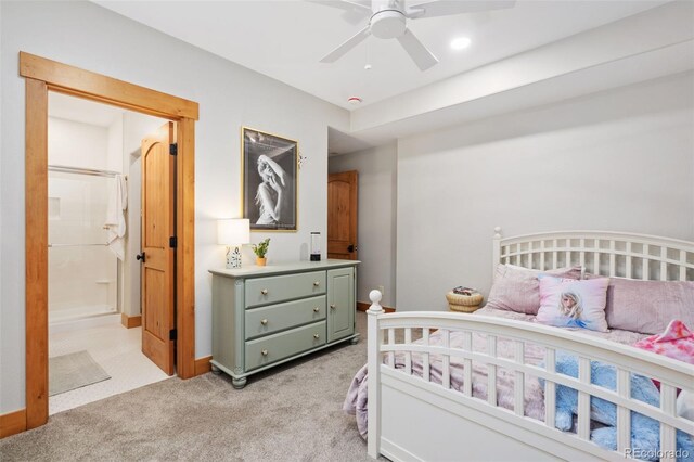 bedroom featuring light carpet, ceiling fan, and ensuite bathroom