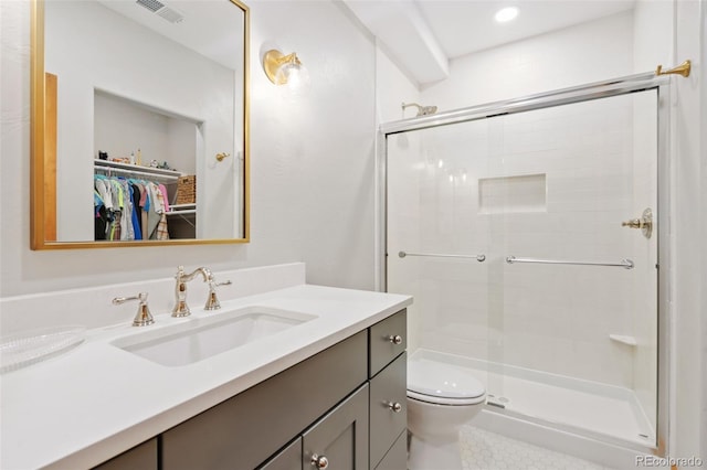 bathroom featuring vanity, toilet, and a shower with shower door