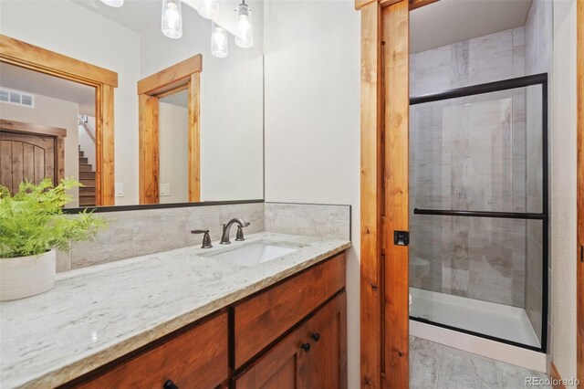 bathroom featuring walk in shower, vanity, and tasteful backsplash