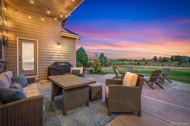 patio terrace at dusk with an outdoor living space and area for grilling