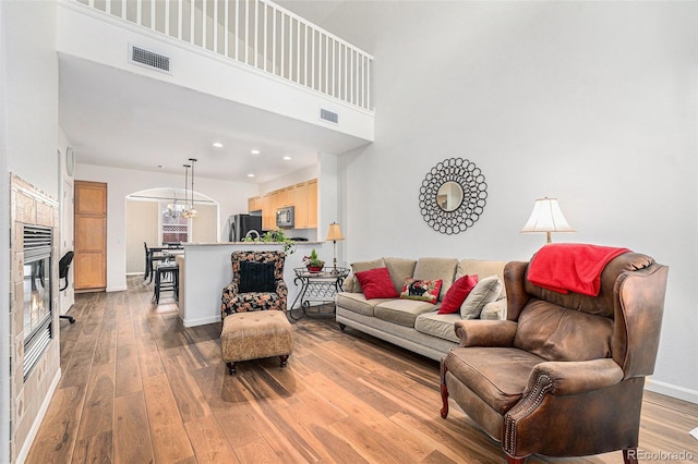 living room featuring a towering ceiling and light wood-type flooring