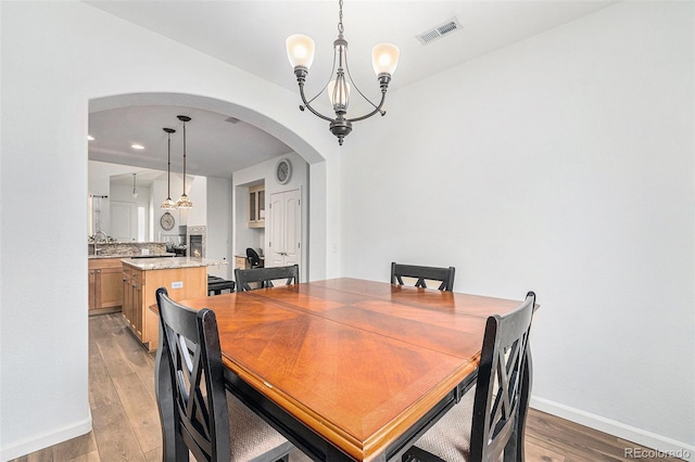 dining room featuring light wood-type flooring and a notable chandelier