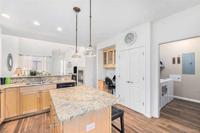 kitchen featuring light brown cabinets, a center island, electric panel, sink, and independent washer and dryer