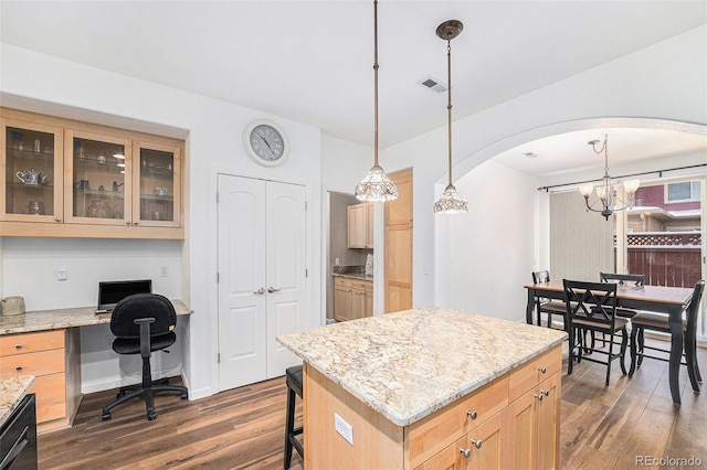 kitchen with a chandelier, dark hardwood / wood-style flooring, a kitchen island, and hanging light fixtures