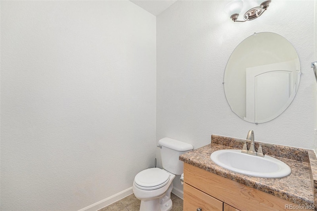 bathroom featuring tile patterned flooring, vanity, and toilet