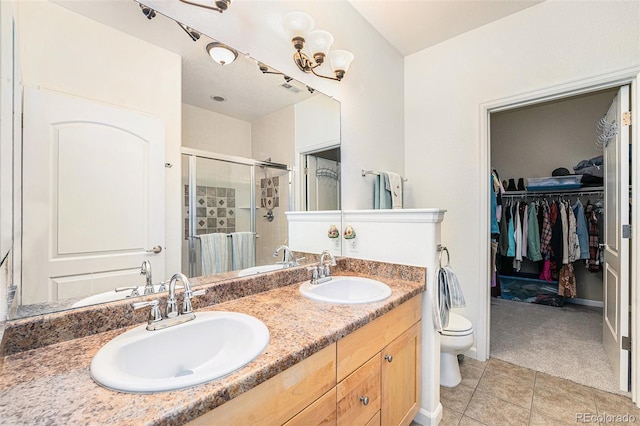 bathroom featuring tile patterned flooring, vanity, toilet, and walk in shower