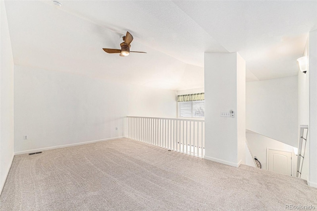 empty room featuring carpet, ceiling fan, and lofted ceiling