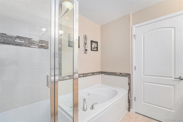 bathroom featuring tile patterned flooring, a textured ceiling, and plus walk in shower