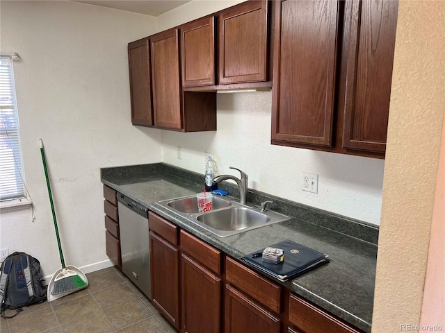 kitchen with dishwasher, sink, dark tile patterned flooring, and dark brown cabinetry