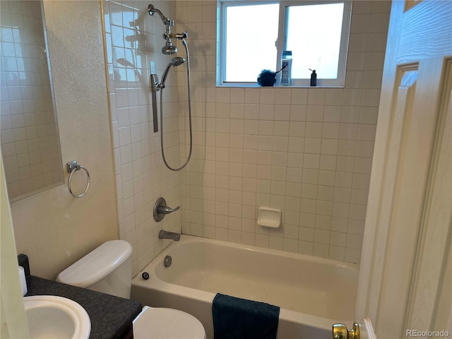 full bathroom with tiled shower / bath, vanity, and toilet