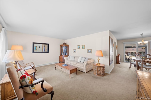 living room featuring a baseboard radiator, baseboards, light colored carpet, and a chandelier