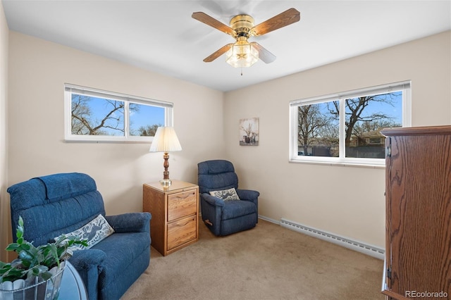 sitting room featuring a baseboard heating unit, baseboards, ceiling fan, and carpet flooring