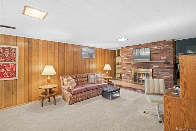 living room with visible vents, carpet floors, a brick fireplace, and wood walls