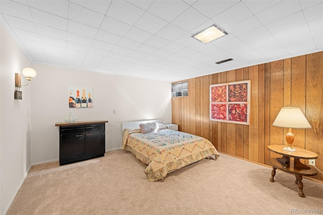 bedroom with visible vents, baseboards, carpet, and wooden walls