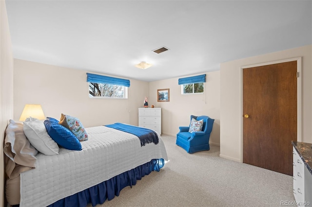 carpeted bedroom featuring visible vents and baseboards