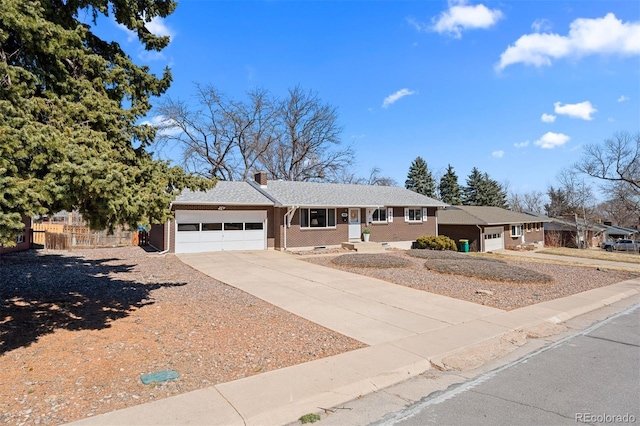 ranch-style home featuring brick siding, fence, a chimney, driveway, and an attached garage