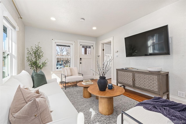 living area with recessed lighting, baseboards, and wood finished floors