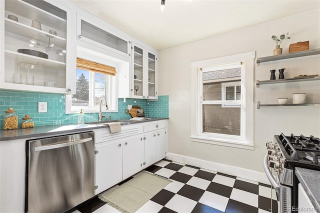 kitchen with tile patterned floors, open shelves, a sink, tasteful backsplash, and appliances with stainless steel finishes