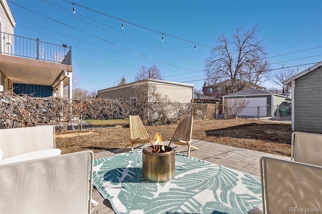 view of patio / terrace featuring an outdoor structure, fence, and a fire pit