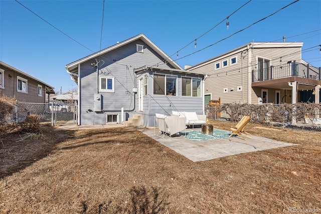 rear view of property with a gate, a patio, fence, and entry steps