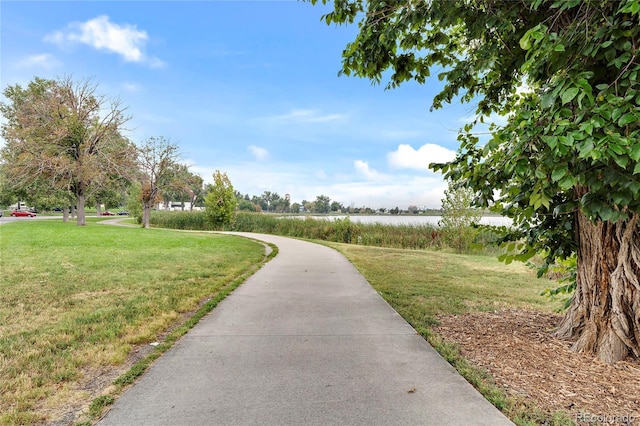 view of home's community featuring a water view and a lawn