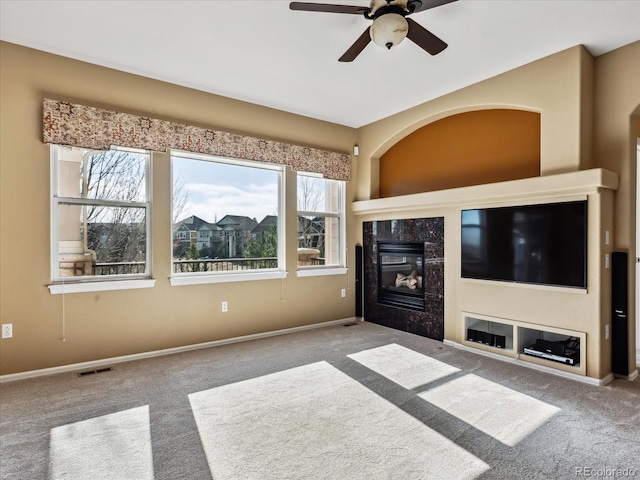 unfurnished living room featuring a ceiling fan, visible vents, carpet floors, baseboards, and a tiled fireplace