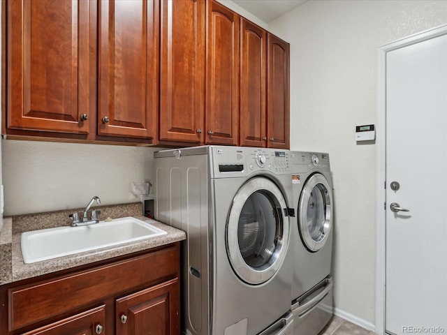 washroom featuring a sink, cabinet space, and washing machine and clothes dryer