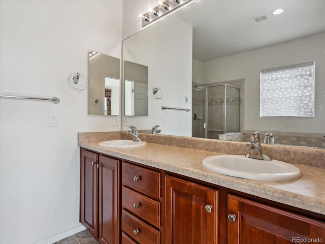 full bathroom featuring double vanity, visible vents, a stall shower, and a sink