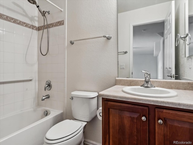 full bath featuring vanity, bathing tub / shower combination, toilet, and a textured wall