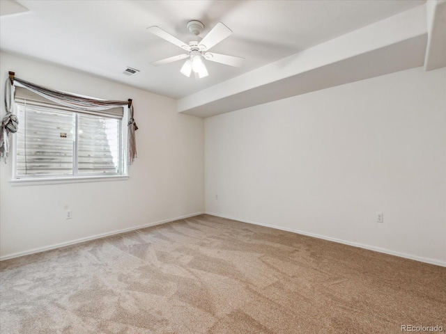 spare room with visible vents, light colored carpet, baseboards, and ceiling fan