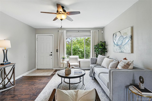 living room with baseboards, a ceiling fan, and wood finished floors