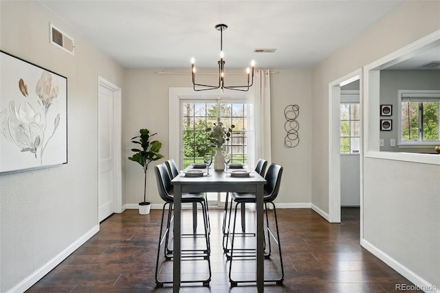 dining room featuring visible vents, dark wood-style flooring, baseboards, and an inviting chandelier