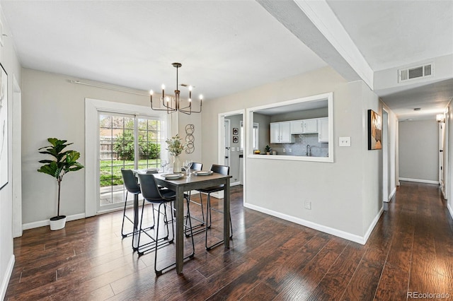 dining area featuring baseboards, dark wood-style floors, a notable chandelier, and visible vents