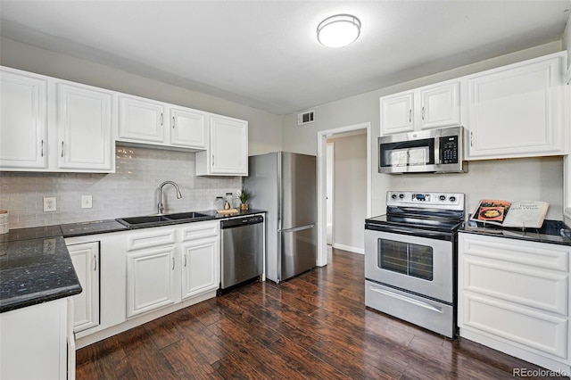 kitchen with visible vents, dark wood-style floors, white cabinets, a sink, and appliances with stainless steel finishes
