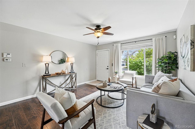 living area featuring baseboards, ceiling fan, and wood finished floors
