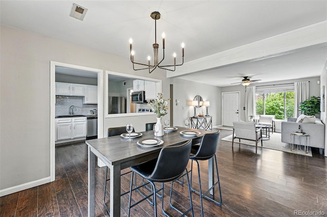dining space with dark wood-style flooring, baseboards, and ceiling fan with notable chandelier