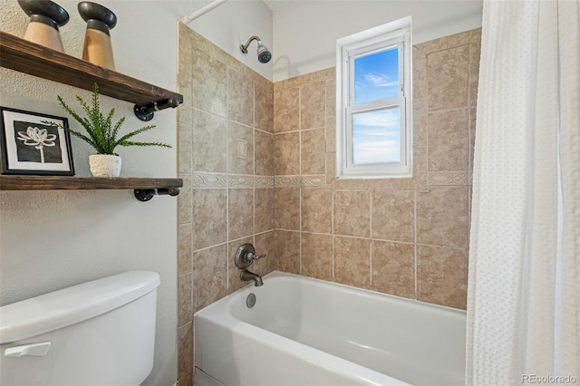 bathroom featuring shower / tub combo and toilet