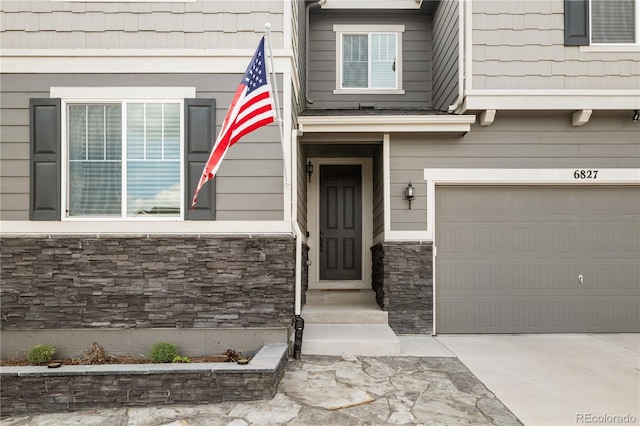 6827 Leilani Ln, Castle Rock, CO 80108 - view of exterior entry with a garage, stone siding, and concrete driveway
