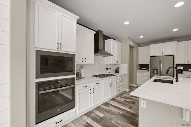 6827 Leilani Ln, Castle Rock, CO 80108 - kitchen featuring appliances with stainless steel finishes, wall chimney range hood, a sink, light wood-style floors, and white cabinetry