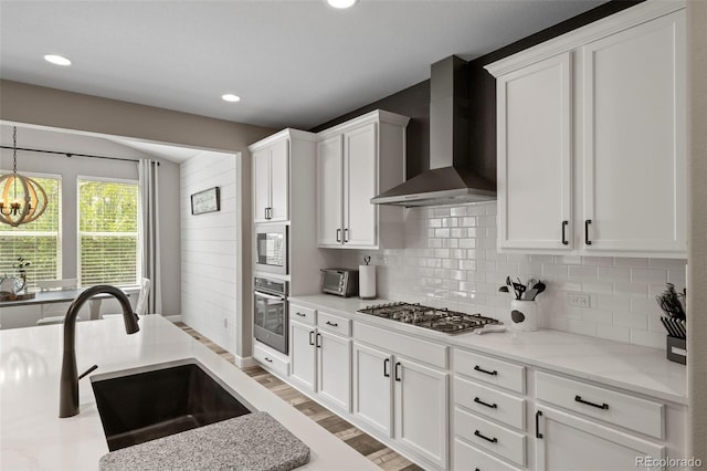 6827 Leilani Ln, Castle Rock, CO 80108 - kitchen with wall chimney exhaust hood, appliances with stainless steel finishes, a sink, tasteful backsplash, and white cabinetry