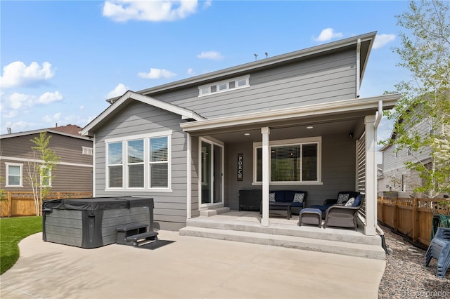 6827 Leilani Ln, Castle Rock, CO 80108 - back of property featuring a hot tub, a patio, outdoor lounge area, and a fenced backyard