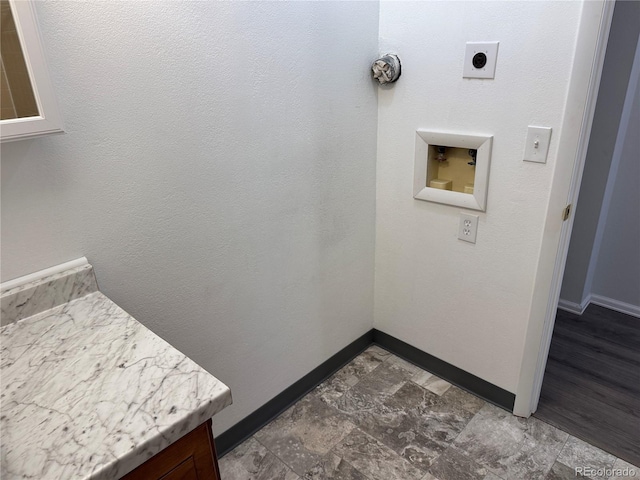 laundry room featuring hookup for a washing machine, cabinet space, stone finish floor, hookup for an electric dryer, and baseboards