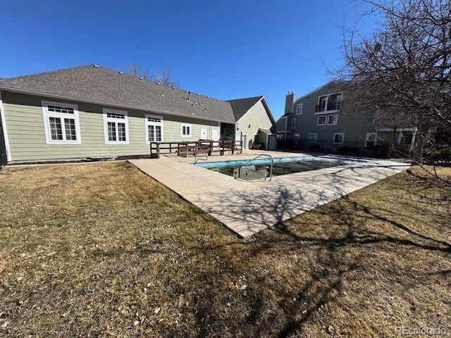 outdoor pool featuring a lawn and a patio