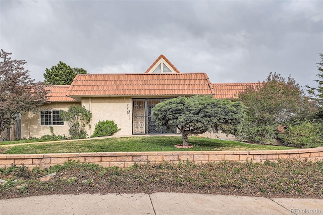 7720 W Quincy Dr, Lakewood, CO 80235 - view of front of home with a tile roof, a front yard, and stucco siding