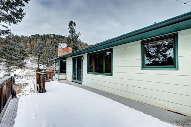 view of snowy exterior with a deck