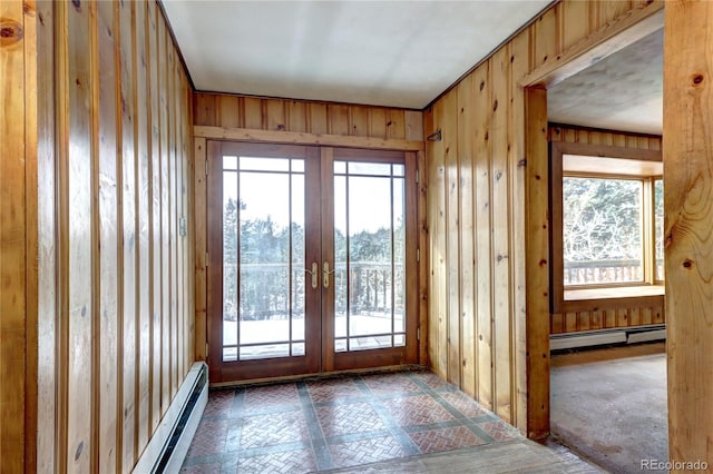 doorway to outside with wooden walls, french doors, and baseboard heating