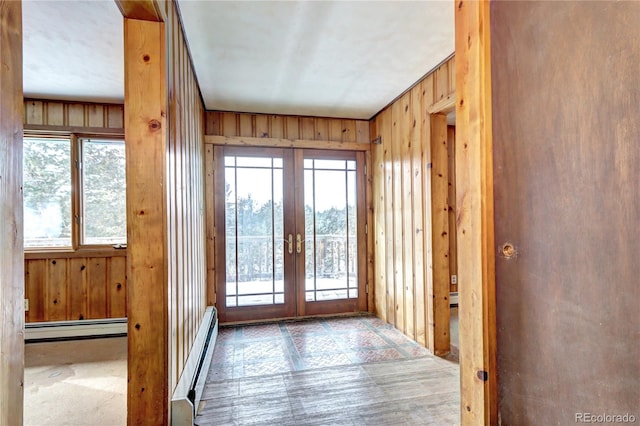 doorway to outside featuring french doors, a baseboard radiator, and a wealth of natural light